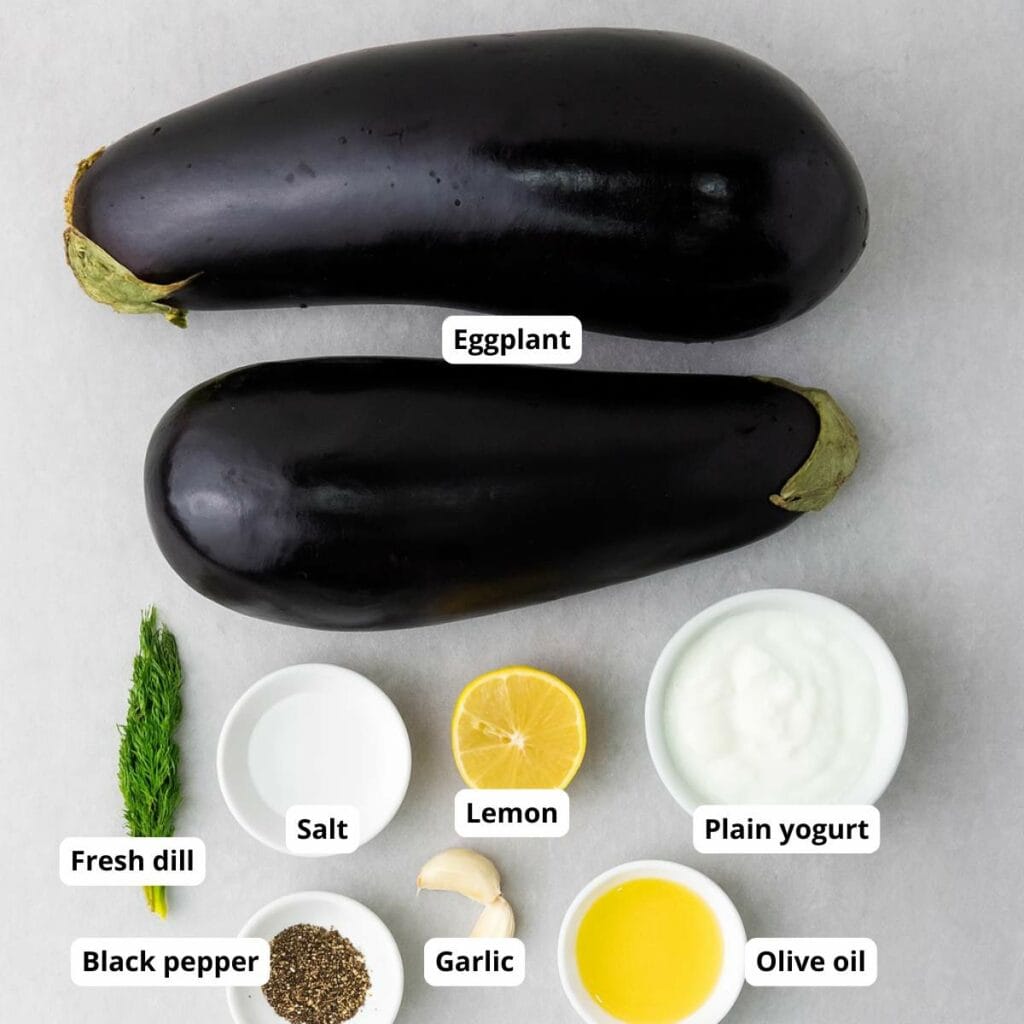 Ingredients for eggplant recipe are arranged below on a light surface. Labels identify each ingredient.