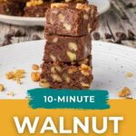 Stacked pieces of walnut fudge on a white plate, with scattered walnuts and chocolate chips.