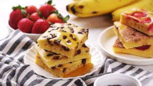 Three chocolate chip banana pancakes stacked on a white plate.