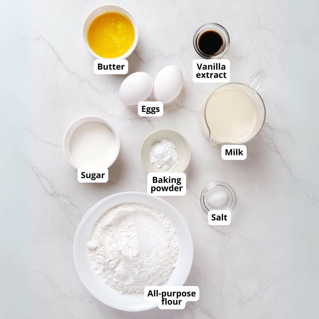 Labeled baking ingredients in bowls: butter, eggs, vanilla extract, milk, sugar, baking powder, salt, and all-purpose flour.