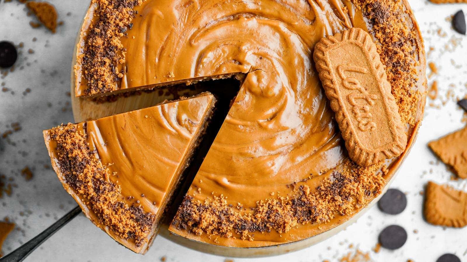 A top-down view of a Biscoff cheesecake with a slice being lifted out.