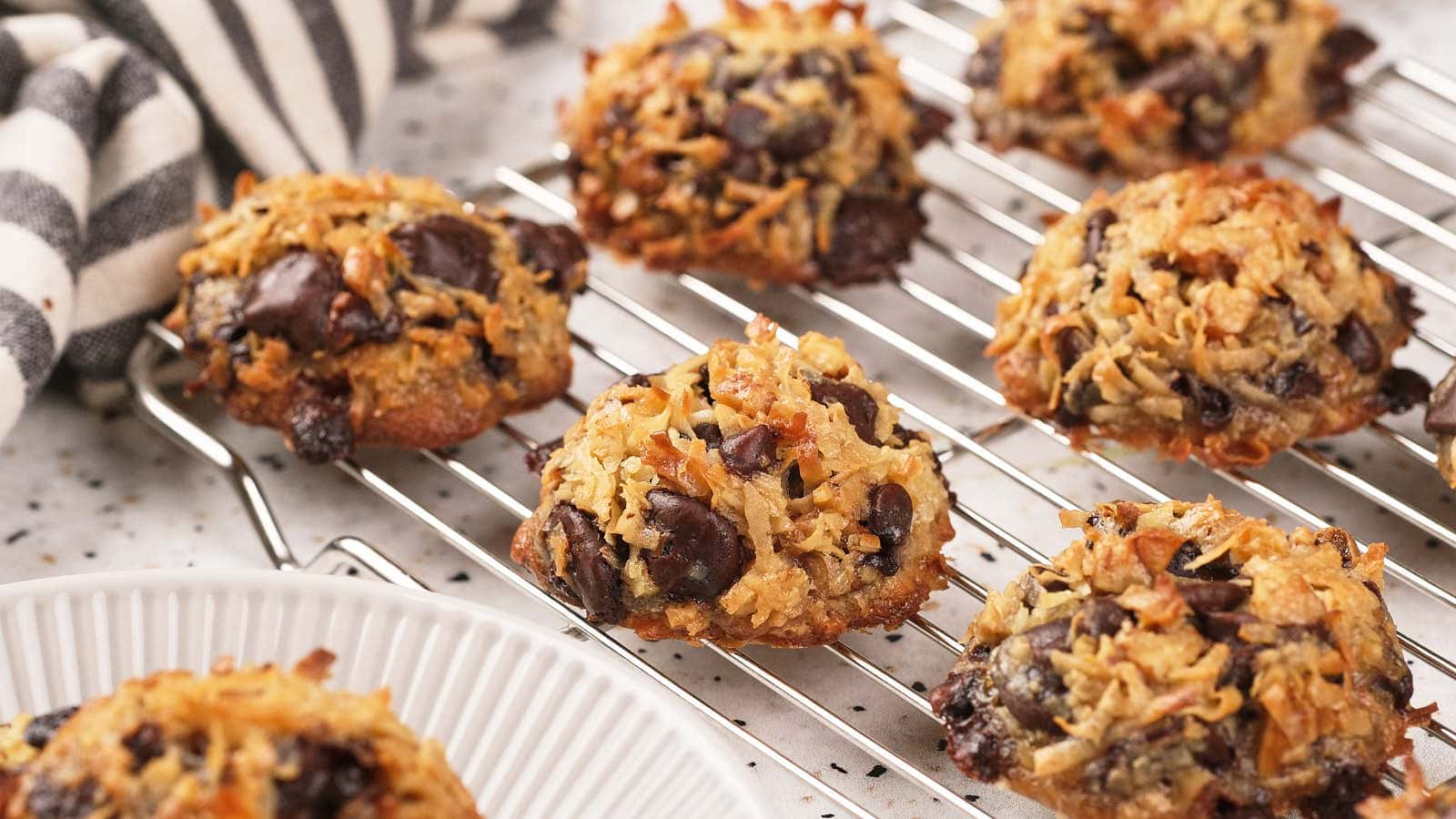 Magic cookies cooling on a black wire rack over a marble surface.