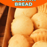 Close-up of round, golden homemade cassava bread rolls arranged in a wooden tray, with a banner reading "25-Minute Homemade Cassava Bread.
