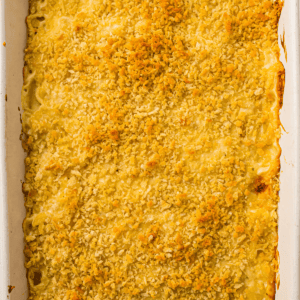 Baked macaroni and cheese in a white rectangular dish, topped with a golden, crispy breadcrumb layer.