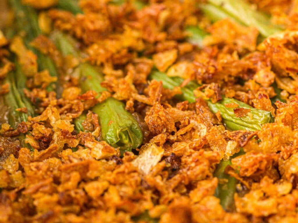 Close-up of a green bean casserole topped with crispy fried onions.