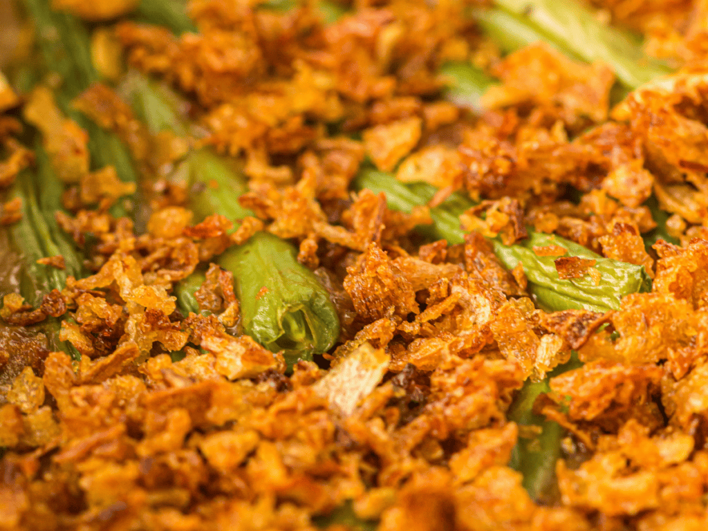 Close-up of a green bean casserole topped with crispy fried onions.