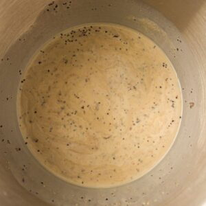 Batter with visible black pepper and spices mixed in, shown inside a metal mixing bowl.