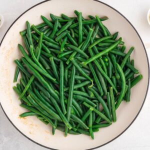 A large pot filled with fresh, uncooked green beans.