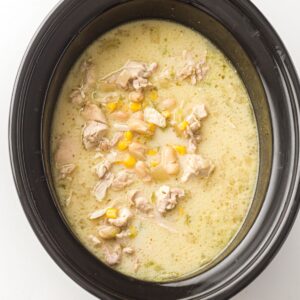 Creamy chicken chili with corn and white beans in a slow cooker.