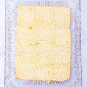 A row of twelve connected slider buns in a glass baking dish.